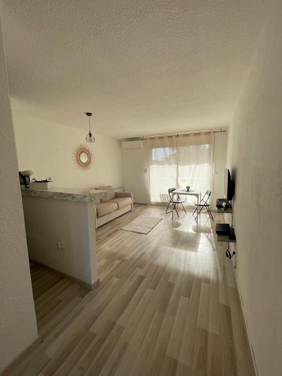 une chambre blanche avec un lit, une table et des chaises dans l'établissement Le Cocoon Évasion Méditerranéenne à 2 min de la plage, à Saint-Laurent-du-Var