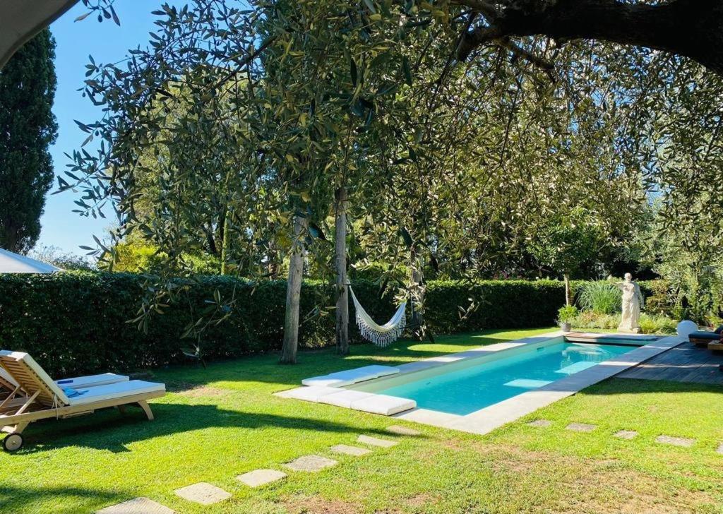 a swimming pool with a hammock in a yard at La Limonaia della Torretta Luxury Private Pool in Florence