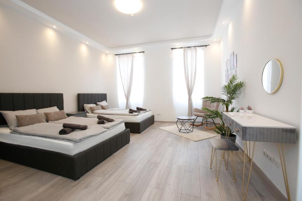 a living room with two beds and a table at LUX Prime Suite Vienna with FREE parking and FAST Internet 600 MBits in Vienna