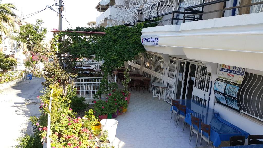 a building with a table and chairs outside of it at Ozgun Apart Hotel in Kusadası