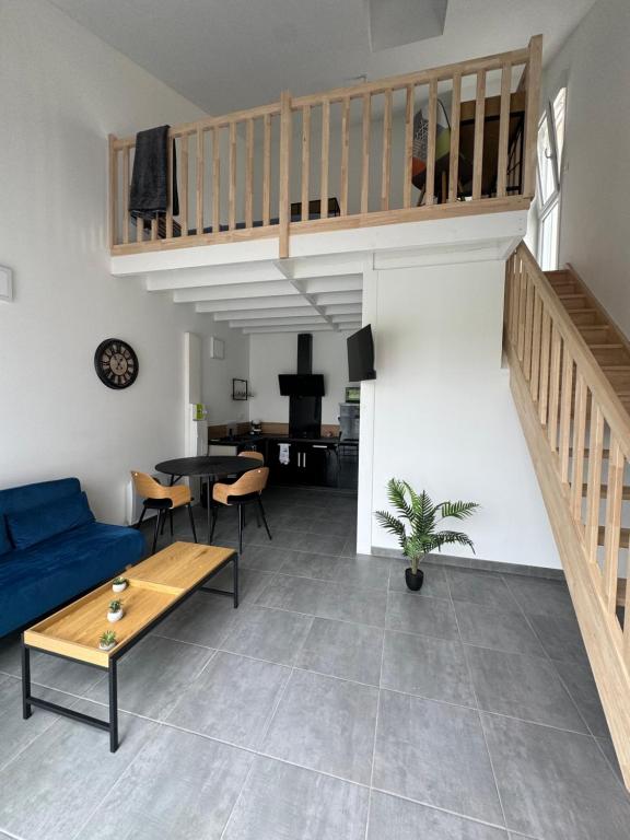 un salon avec un canapé bleu et une table dans l'établissement Nathôme 1, à Aleçon