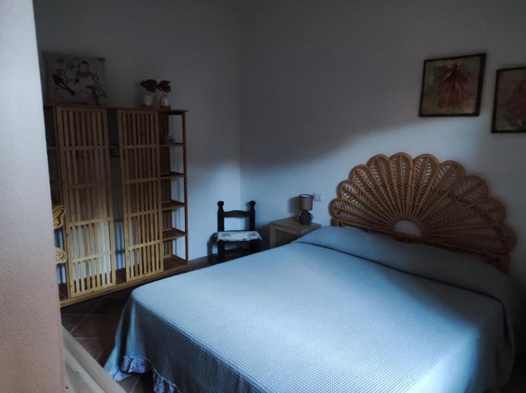 Schlafzimmer mit einem Bett mit blauer Tagesdecke in der Unterkunft Rena Majore Home in Rena Majore