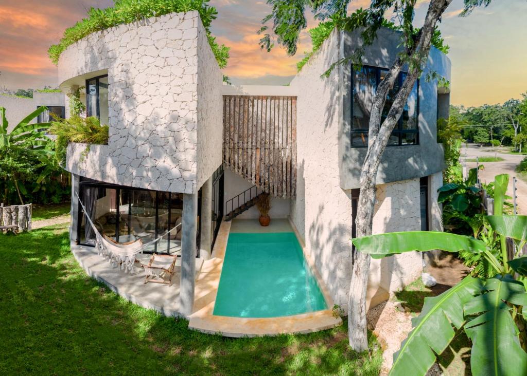 a house with a swimming pool in the backyard at 2 Tropical Bohemian Villas-2 Priv Pool-BBQ 3A-3B in Tulum