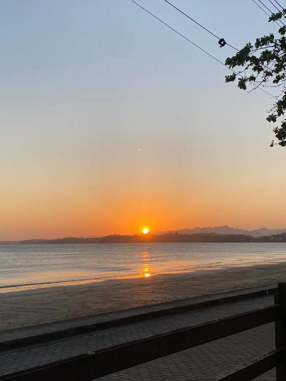 a sunset on the beach with the sun setting at Cantinho da Dê in Anchieta