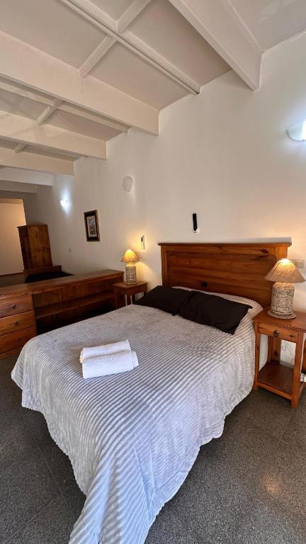 a bedroom with a large white bed with two tables at PALMARES DEL BOULEVARD - Aeropuerto Internacional Taravella - Campus Siglo 21 - Campus Blas Pascal - Sanatorio Allende - Estadio Kempes - Quorum - Mujer Urbana - Complejo Ferial Córdoba in Córdoba
