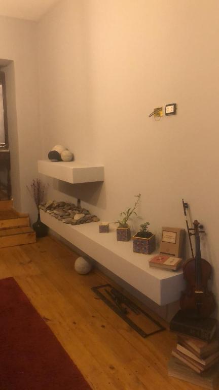 a room with a shelf with books and a guitar at La Plaza in Azul