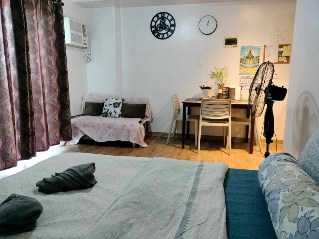 Sala de estar con cama y mesa con silla en Anya and Carl's Comfy, en Mactan