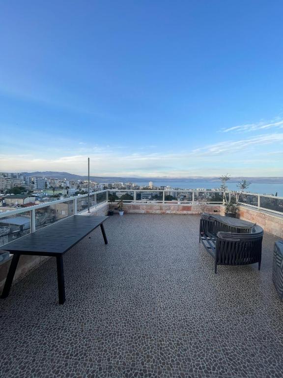 a patio with a table and a bench on a roof at חופשה מושלמת על הכנרת in Tel Aviv
