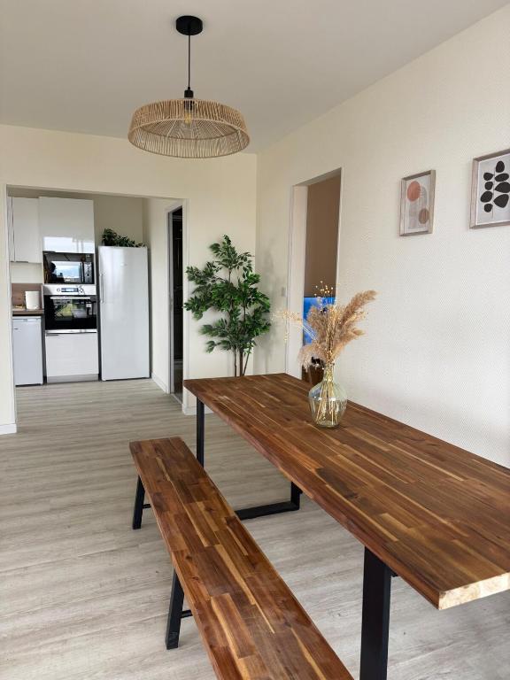 une salle à manger avec une table en bois et deux bancs dans l'établissement Appt Ideal groupes, prox Eurexpo, à Saint-Priest