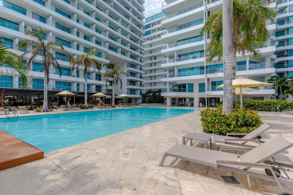 een zwembad met ligstoelen en een gebouw bij Escapada 5 estrellas frente al mar - sonest morros in Cartagena