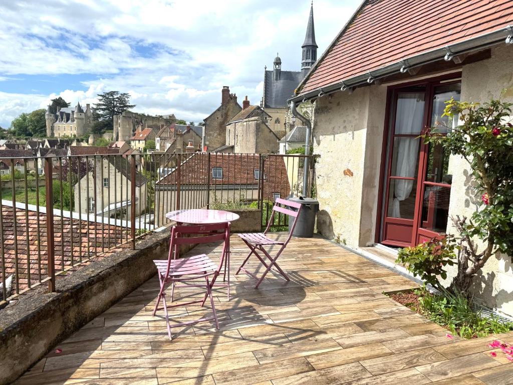 a patio with two chairs and a table on a balcony at La Grange de Montrésor in Montrésor