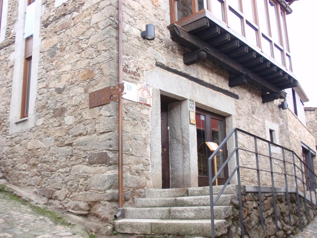 un edificio de piedra con escaleras que conducen a una puerta en Posada Miranda, en Miranda del Castañar