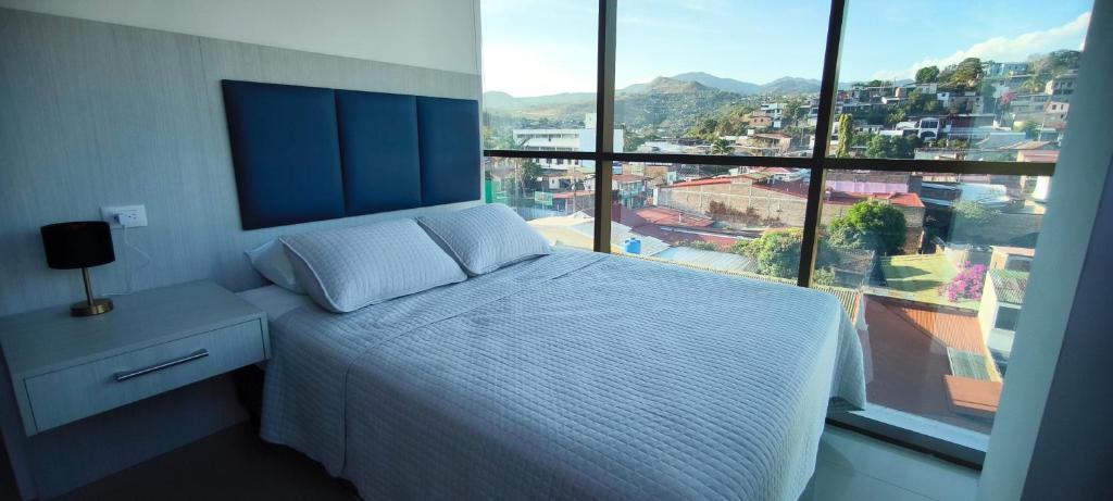 a bedroom with a bed and a large window at Apartamento en el centro de Matagalpa in Matagalpa
