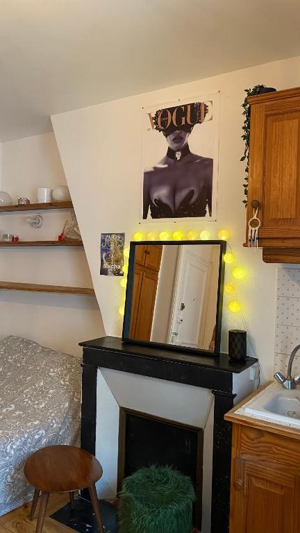 Cette chambre dispose d'une cheminée avec un miroir et un lavabo. dans l'établissement Charmant Studio à Saint-Germain Des près, à Paris