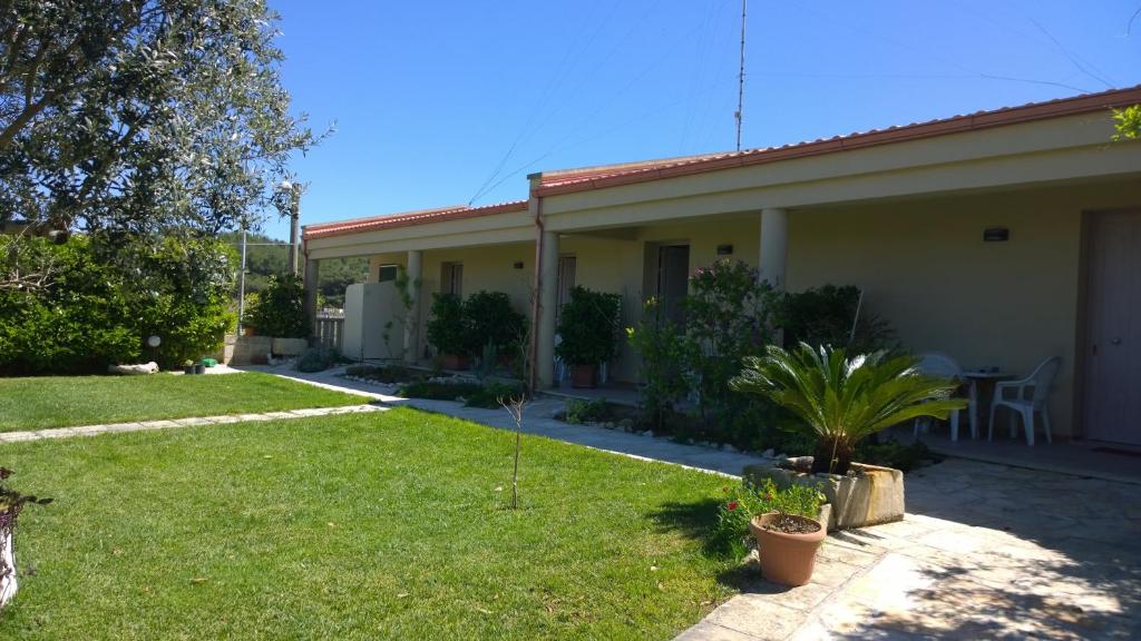 una casa con un cortile verde accanto a un edificio di B&B Borgo Minerva a Otranto