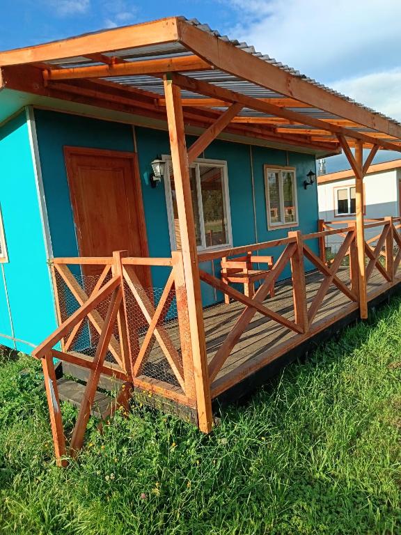 a house with a wooden deck with a roof at Cabañas Manolo in Osorno
