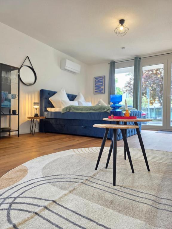 a living room with a table and a bed at Design-Apartments I Klimaanlage I Boxspring I Nespresso I Parklplatz in Weil am Rhein