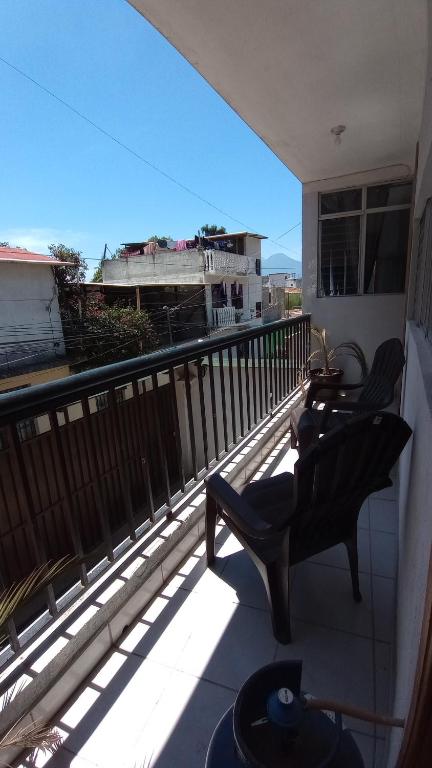 a balcony with a chair and a view of a building at CENTRAL APARTMENT, casa cuc in Panajachel