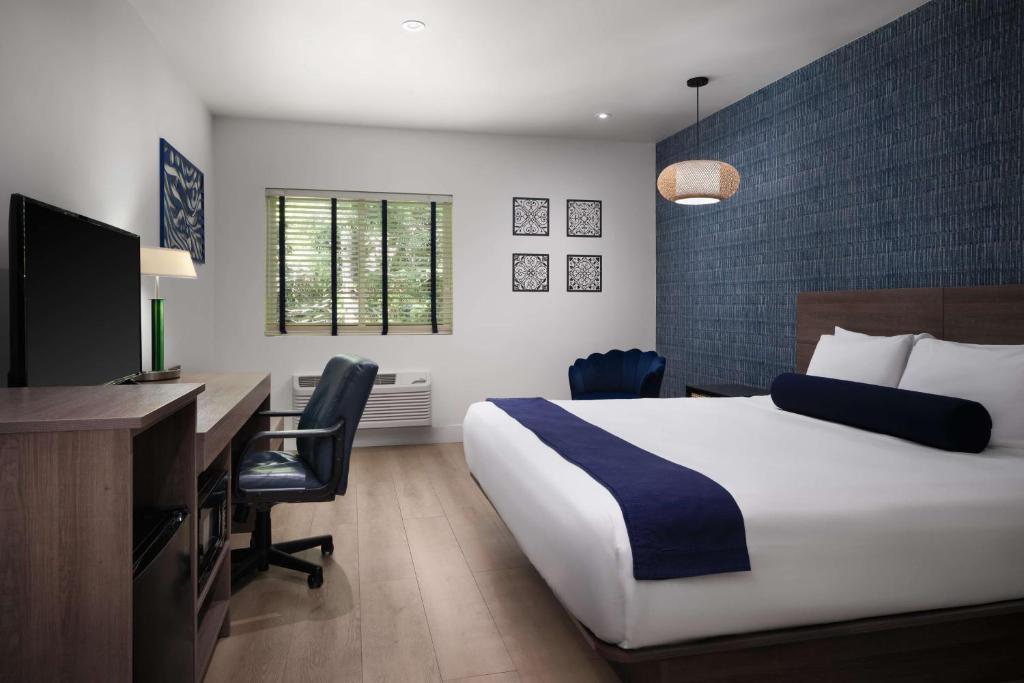 a bedroom with a bed and a desk with a computer at Hotel Zico, BW Signature Collection in Mountain View