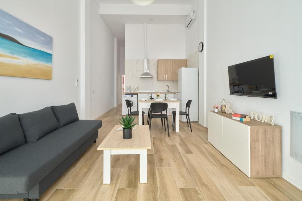 a living room with a couch and a table at Hasta para 6 viajeros, Luz Natural Cocina Equipada in Algeciras
