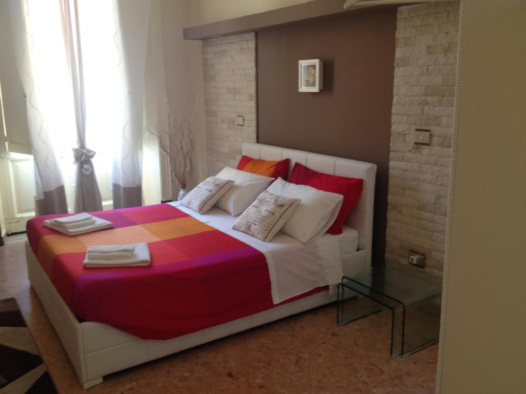 Un dormitorio con una cama grande con sábanas y almohadas coloridas. en Don Mico 'Case Vacanze', en Riposto