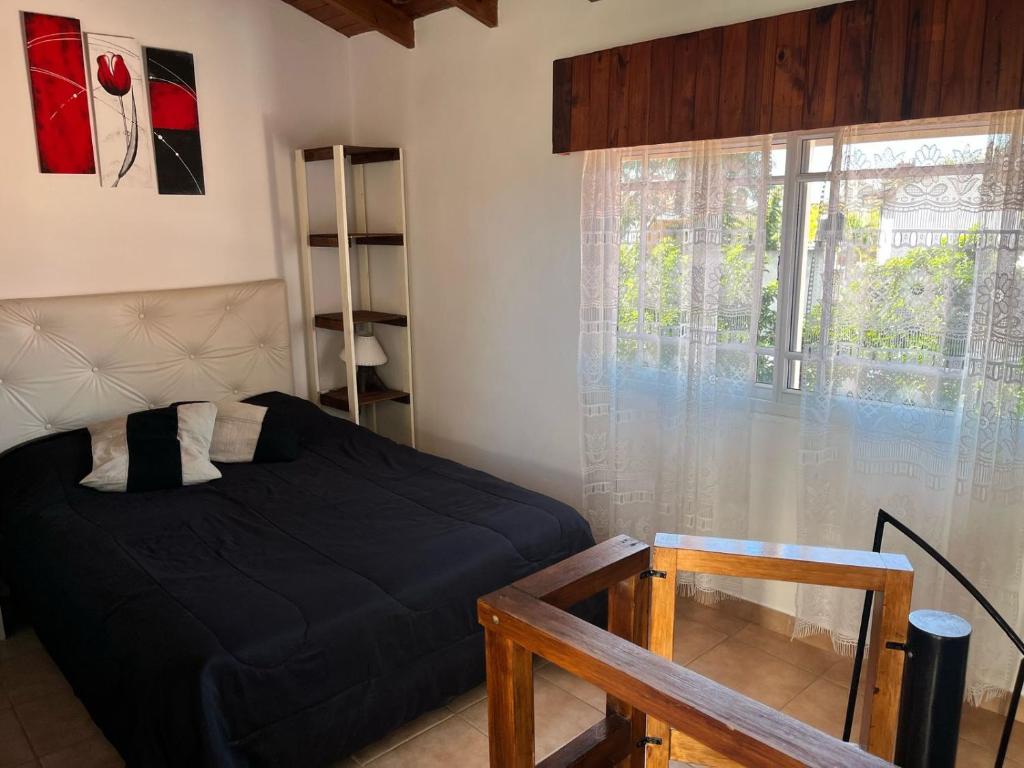 a bedroom with a black bed and a window at Depto calle 15 in San Clemente del Tuyú