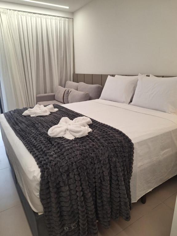 ein Schlafzimmer mit einem Bett, auf dem zwei Handtücher liegen in der Unterkunft Beach Haus #23 - Flat de luxo com terraço in João Pessoa