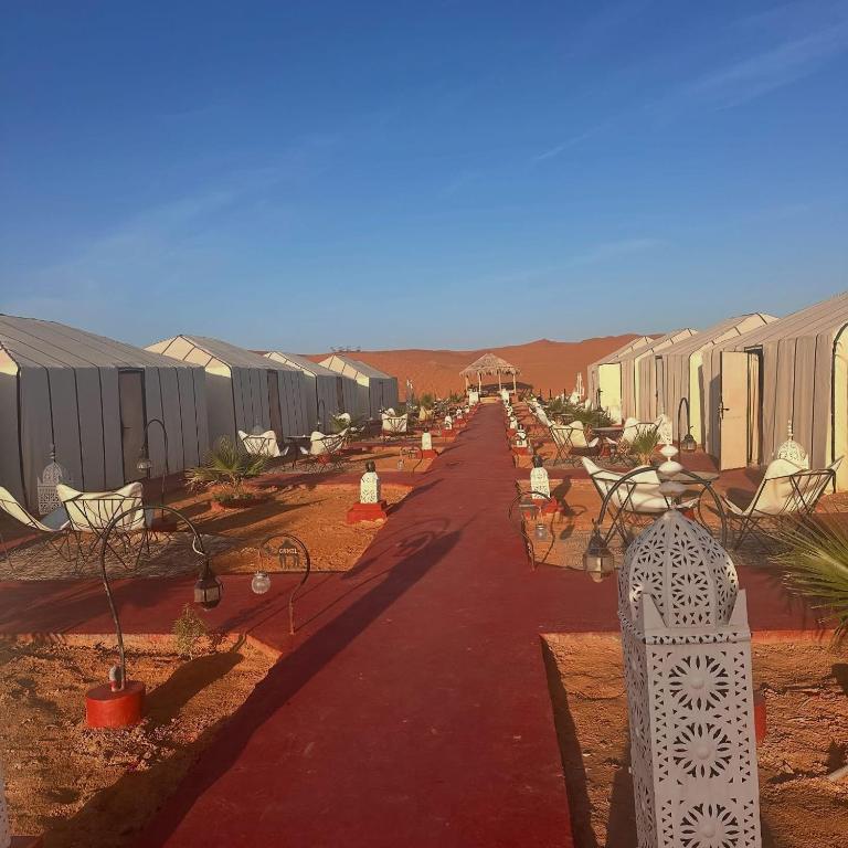a road leading to a row of houses in the desert at Nada luxury desert camp in Merzouga
