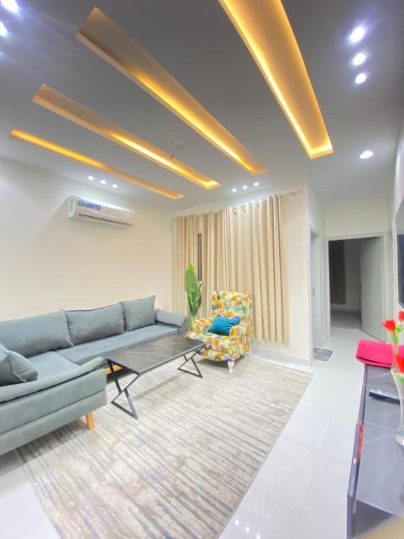 a living room with a couch and a chair at فخامة مكة ثلاث غرف in An Nikāshah