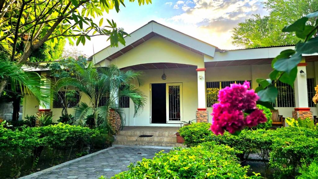 a small yellow house with a courtyard at La Paloma Hostal in Moyogalpa