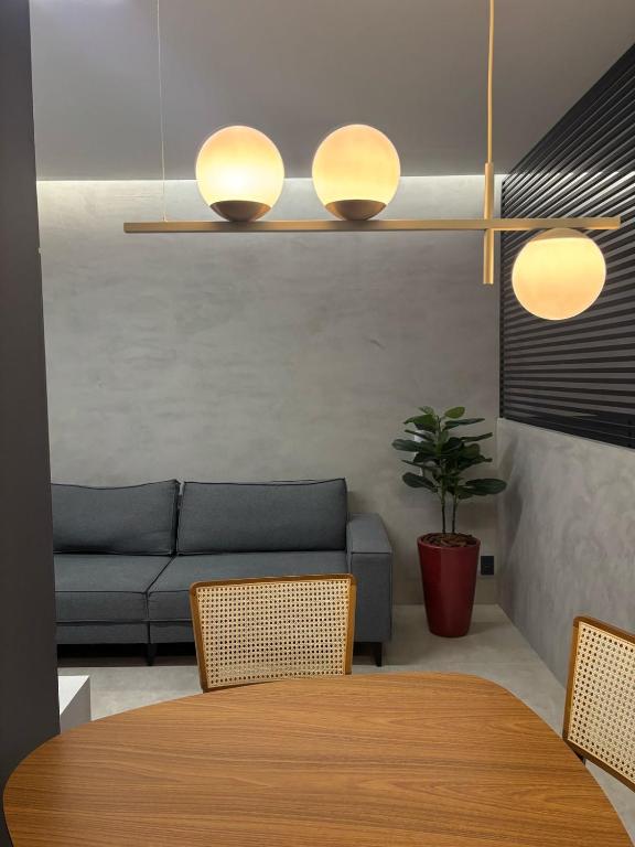a living room with a table and a couch at Apartamento Loft Lazer Completo in Belo Horizonte