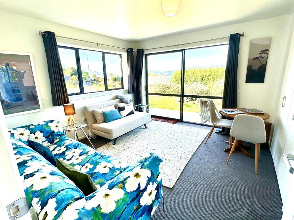 ein Wohnzimmer mit Sofa und Tisch in der Unterkunft Kererū Garden Apartment in Dunedin