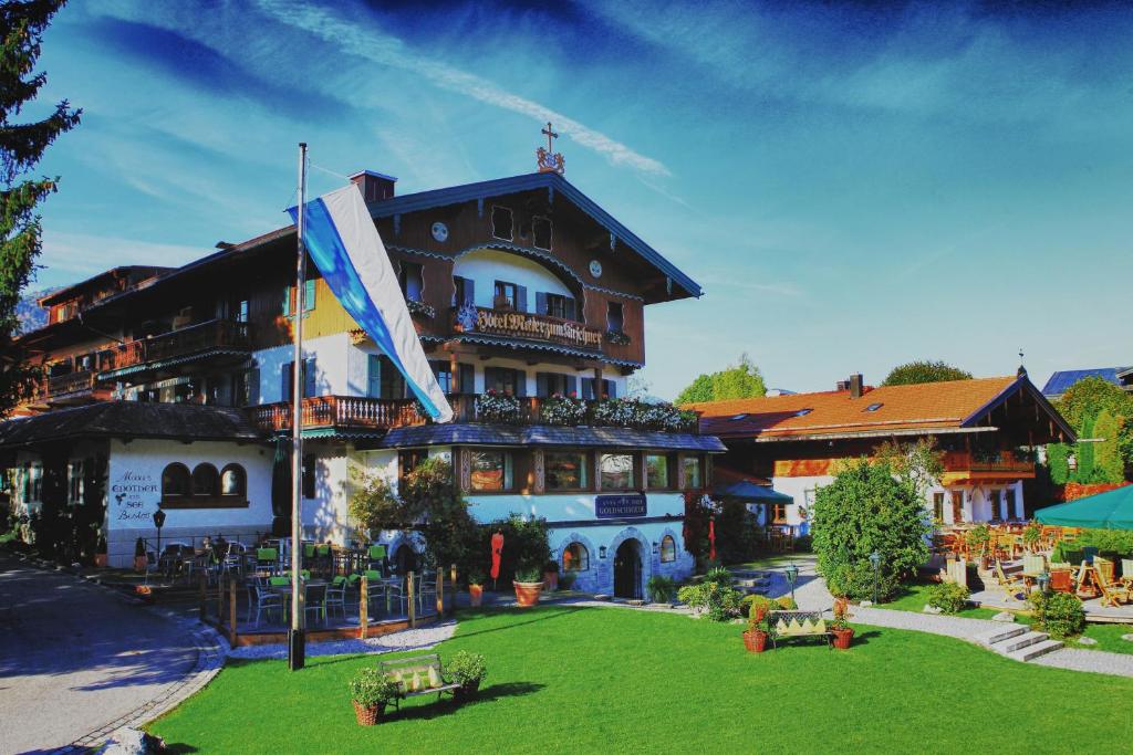 ein großes Gebäude mit grünem Rasen davor in der Unterkunft Hotel Maier zum Kirschner in Rottach-Egern