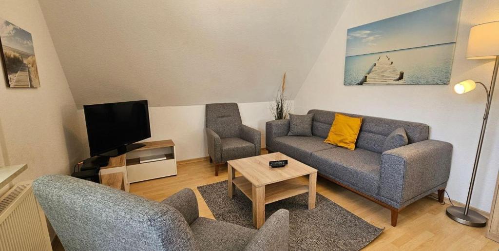 a living room with a couch and a tv at Wohnung-D-306 in Böhl