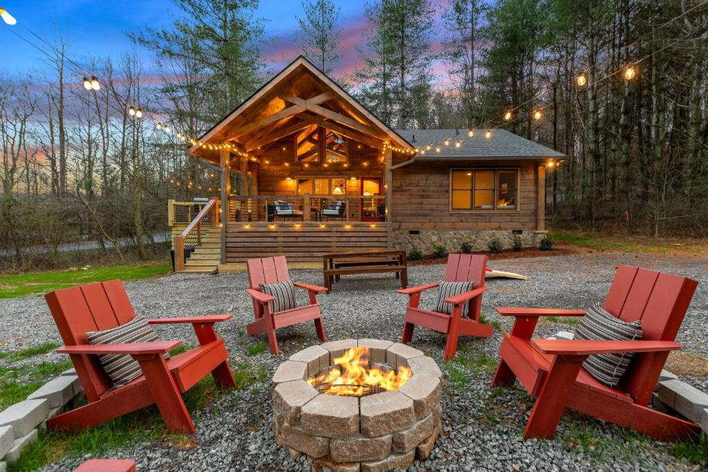 a fire pit in front of a log cabin at Family fun, romantic Hot Tub, Firepit, King Bed 15 min from Blue Ridge & Ellijay in Blue Ridge
