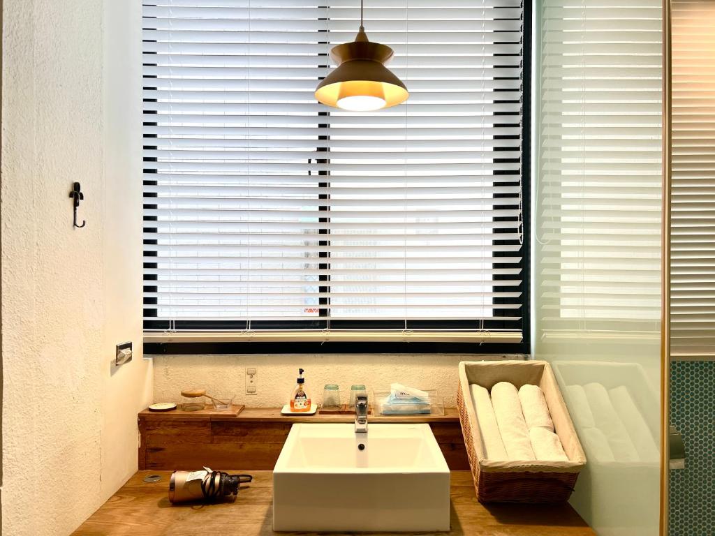 a bathroom with a sink and a large window at Hour Roots in Tainan