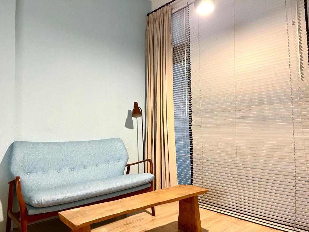 a room with a bench and a table and a window at Hour Roots in Tainan