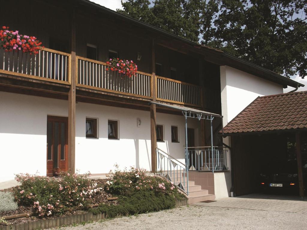 ein weißes Gebäude mit einem Balkon und Blumenkästen darauf in der Unterkunft Gästehaus Leithen in Bad Birnbach