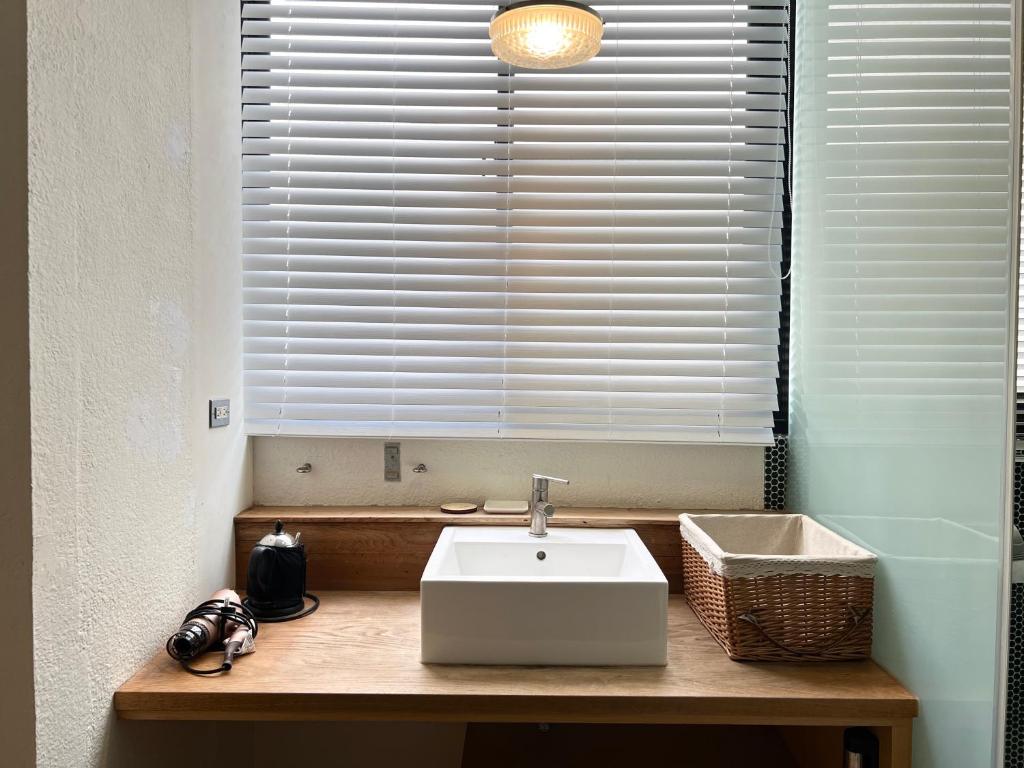 a bathroom with a white sink and a window at Hour Roots in Tainan