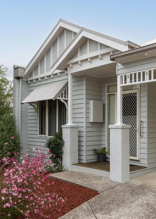 a house with a front porch with flowers at Fermoy Cottage in Healesville