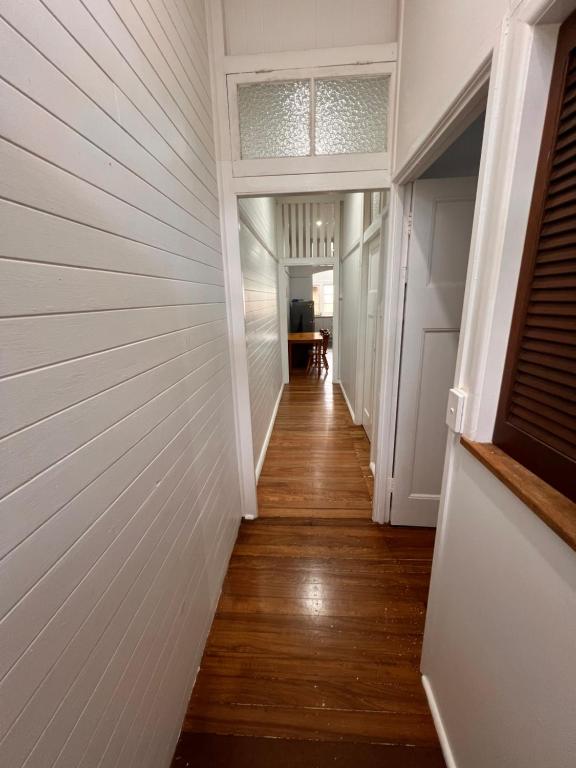 a hallway of a home with white walls and wood floors at Ryan's Rest Boutique Accommodation in Cairns