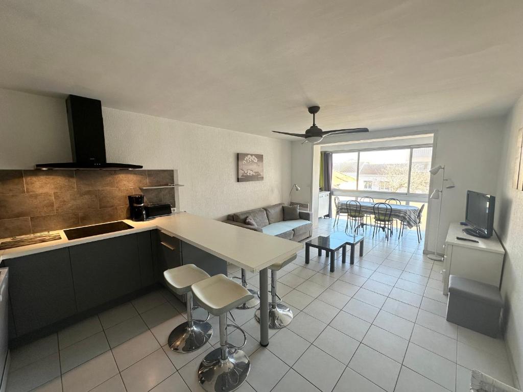 une cuisine et un salon avec une table et des chaises dans l'établissement Location saisonnière à Valras-Plage pour 2 personnes - FR-1-781-95, à Valras-Plage