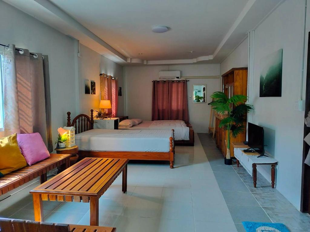 a hotel room with a bed and a couch at Granny's home บ้านคุณย่า in Lampang