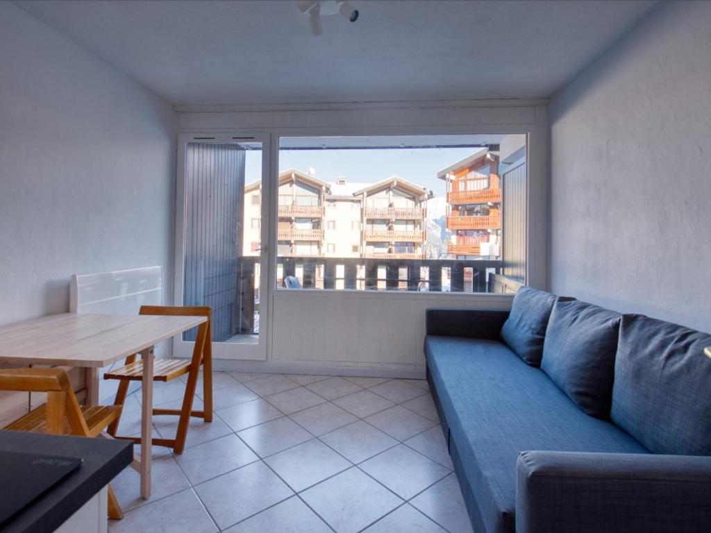 un salon avec un canapé bleu et une table dans l'établissement Studio rénové pour 4 pers avec balcon, animaux admis - Morillon - FR-1-642-103, à Morillon