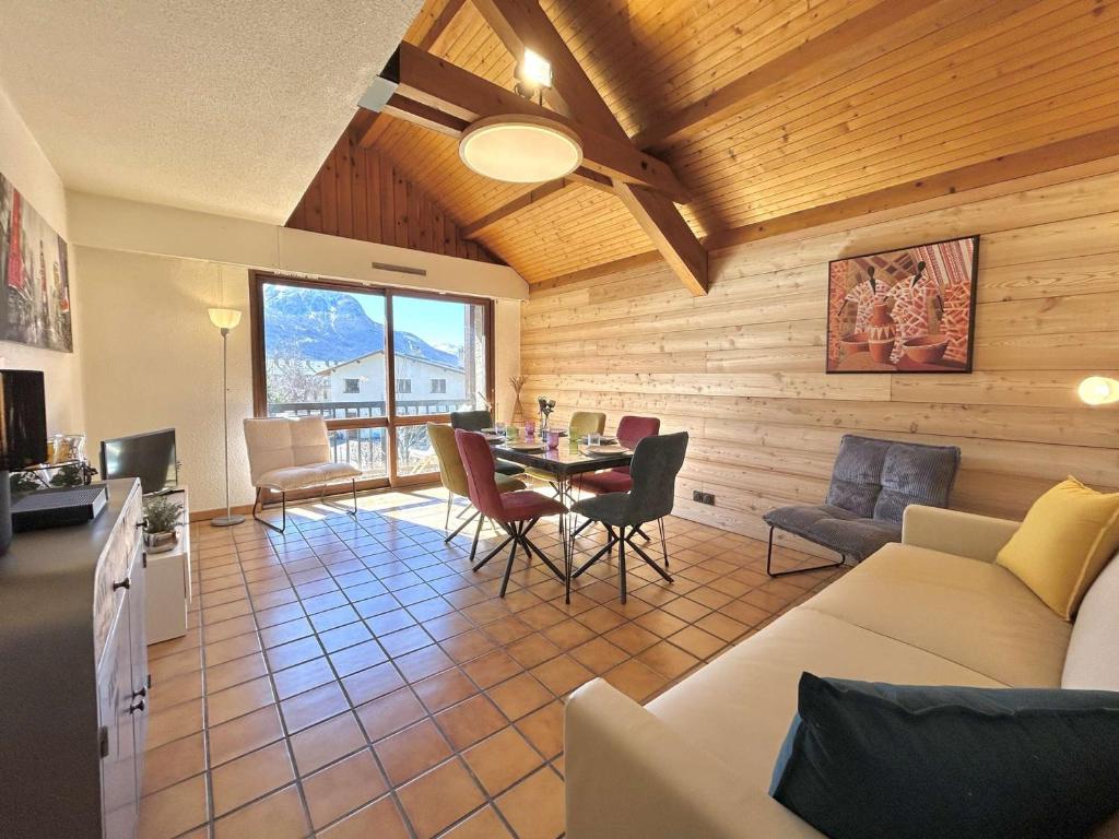 un salon avec un canapé, une table et des chaises dans l'établissement Appartement 3 pièces à Briançon, balcon sud, parking, jusqu'à 6 personnes - FR-1-330C-152, à Briançon