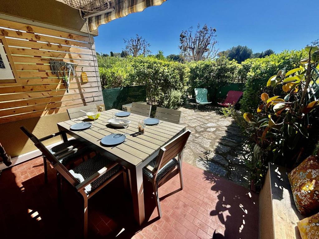 une table et des chaises en bois sur une terrasse dans l'établissement Appartement calme proche plage, terrasse, proche animations - FR-1-816-29, à Bormes-les-Mimosas