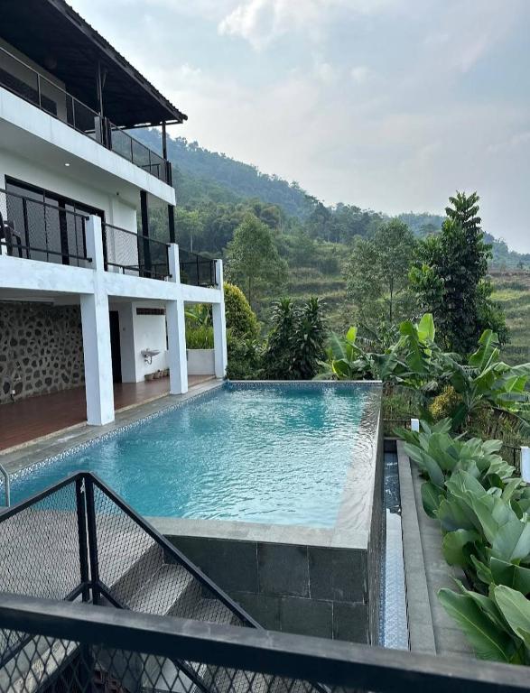 a swimming pool in front of a house at Villa lofous in Pasirpogor