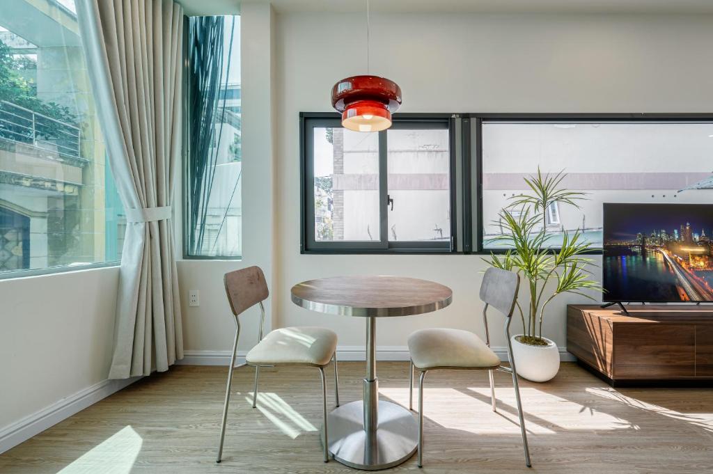 Camera con tavolo, sedie e TV di Home by CR Concept in Center City ad Ho Chi Minh
