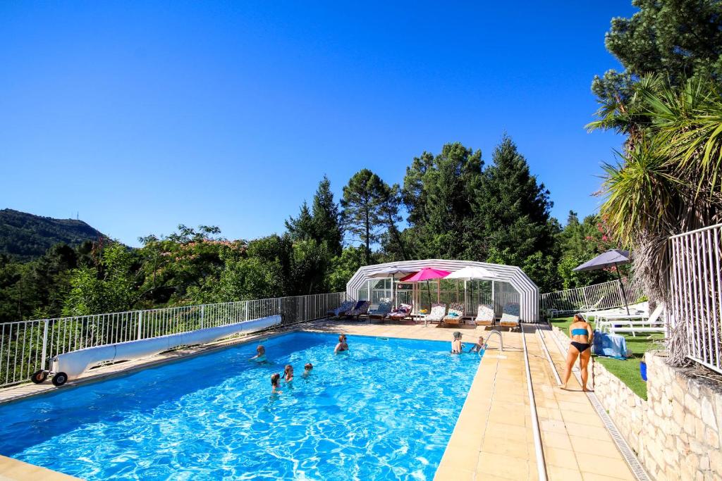 eine Gruppe von Menschen in einem Schwimmbad in der Unterkunft Domaine de Ravel Ushuaïa Villages in Saint-Jean-du-Gard