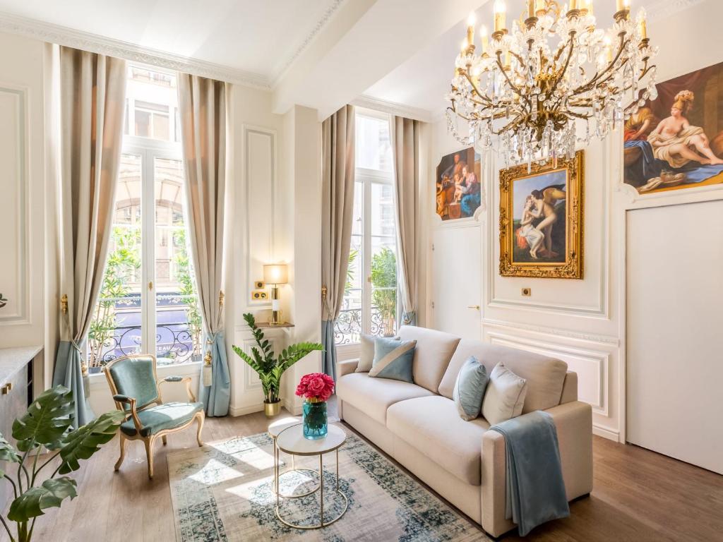 - un salon avec un canapé et un lustre dans l'établissement Merveil - Luxury Suite - Louvre - Aboukir V, à Paris